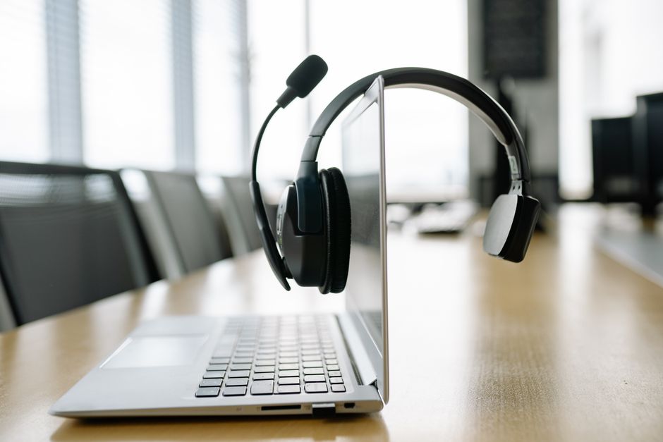Laptop elegante com um headset sem fio em um ambiente moderno e iluminado.