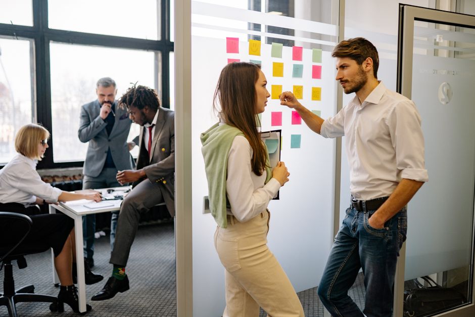 Um grupo de profissionais participando de uma sessão de trabalho em equipe em um ambiente de escritório contemporâneo.