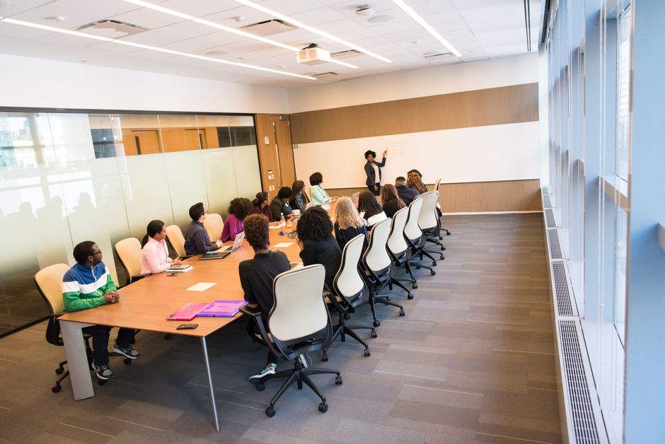 Um grupo diversificado colaborando ativamente em um ambiente moderno de sala de conferências iluminada.